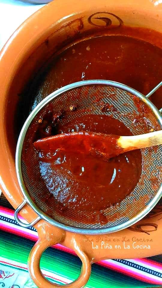 Straining the red chile sauce for pork
