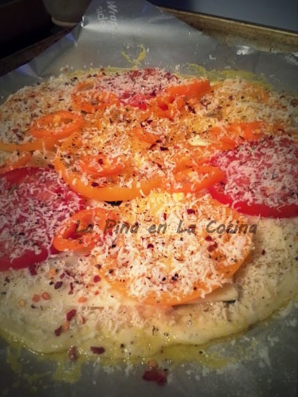 A layer of roasted garlic paste, mozzarella, sliced tomatoes, Parmesan, oregano and pepper flakes.