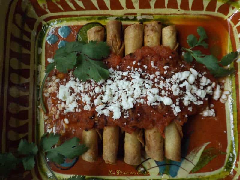 Codzitos on a Mexican platter garnished with crumbled cheese and salsa