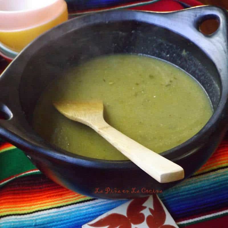 Tomatillo Salsa warm in the pot with wooden spoon 