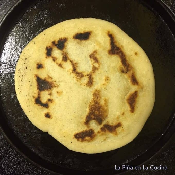 Pupusa cooking on a cast iron griddle