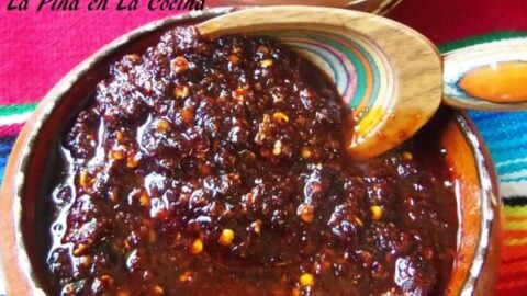 salsa macha in a Mexican clayware bowl with a wooden spoon