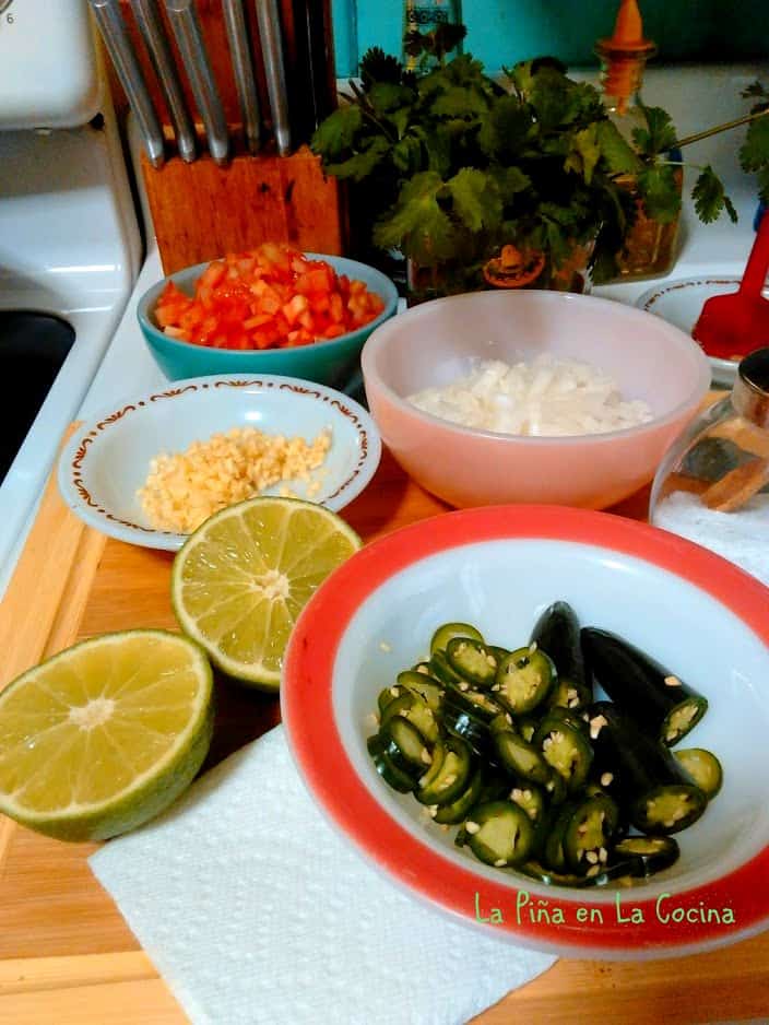 Ingredients for seafood a la Mexicana, onion, garlic, serrano, tomato, cilantro