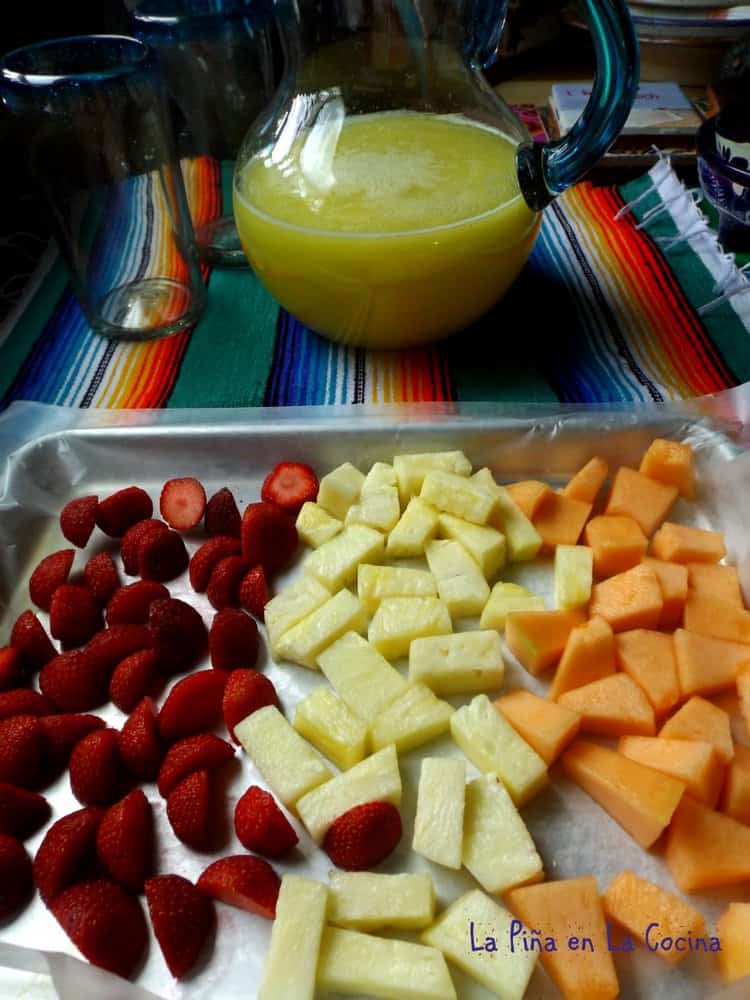 Pineapple Agua Fresca In Glass Pitcher with Tray Of Fresh Fruit