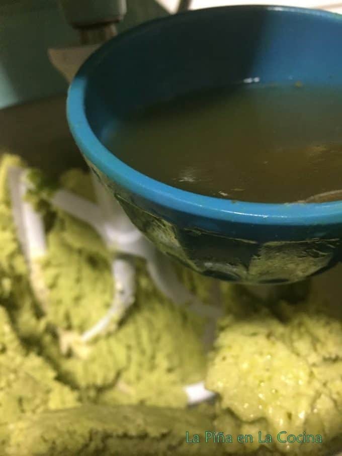 Adding chicken broth to masa in stand mixer