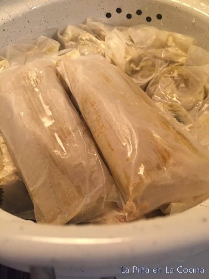 Tamales wrapped individually in deli paper in steamer pot all done cooking.