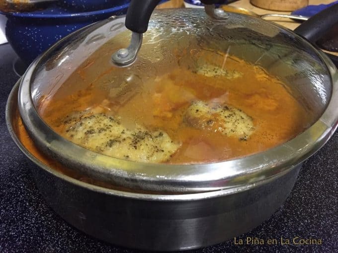 Red Chicken Pipian Simmering in Skillet with lid