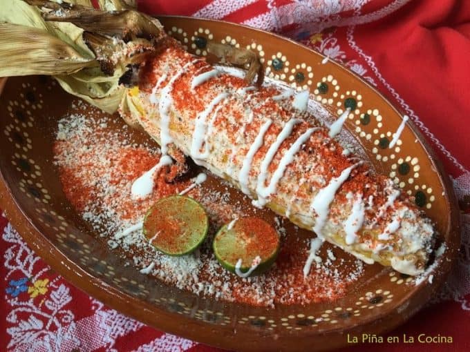 Grilled elote with all the garnishes plated