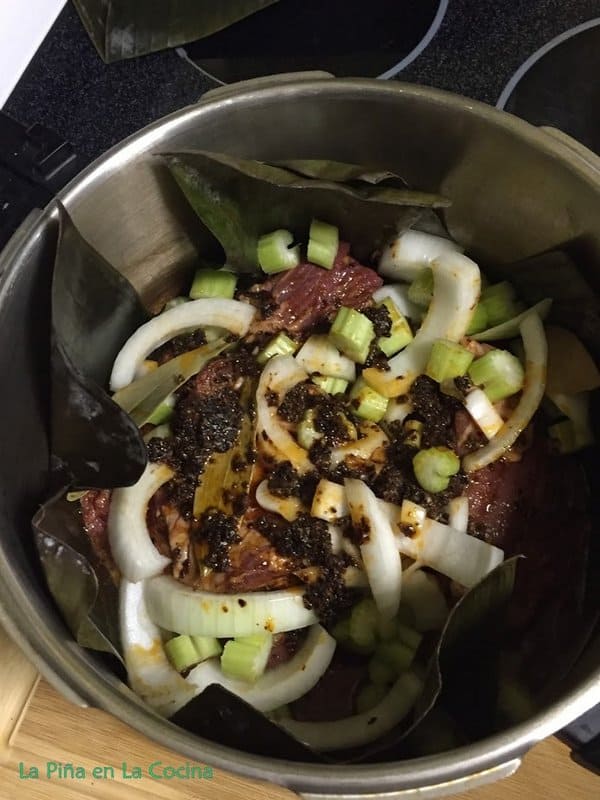 Beef, seasoning and vegetables all in banana leaf line pressure cooker