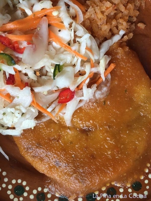 Pupusa with salsa and curtido on a plate close up