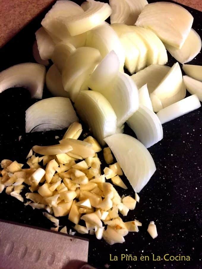Onions and garlic prepped on cutting board