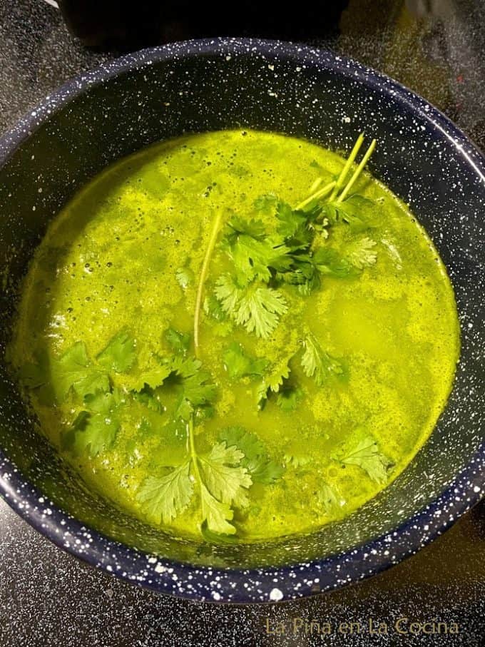 Adding cilantro to simmering broth