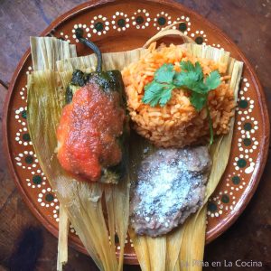 Tamachile garnished with salsa served with rice and beans