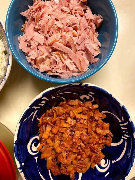 A bowl of chopped ham and a bowl of crispy bacon bits