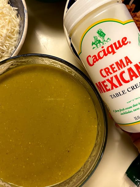 A bowl of cooked salsa verde and a jar of Mexican crema