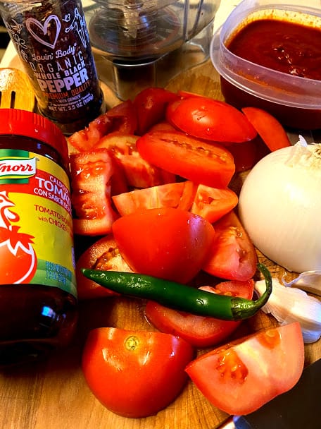 Ingredients for red salsa, uncooked tomatoes, serrano chile, onion, garlic, tomato bouillon 