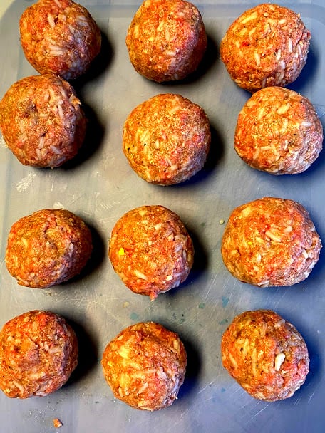 uncooked meatballs on plastic cutting board