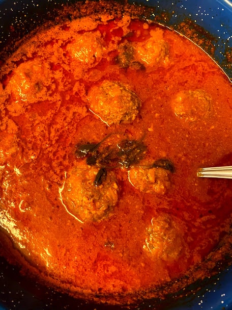Stuffed meatballs finished cooking in salsa still in the pot, top view