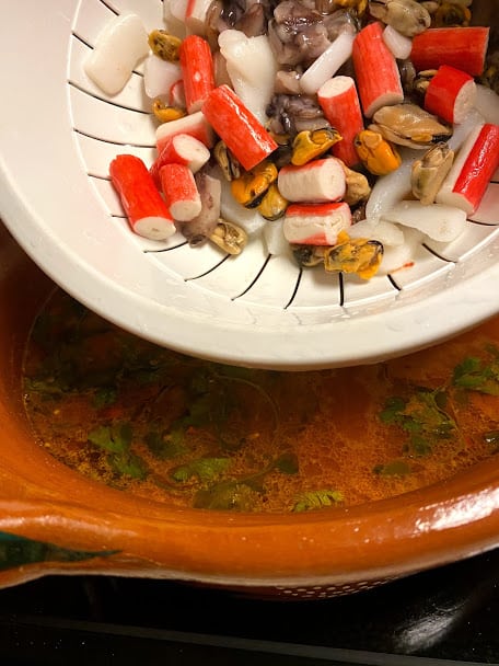 Seafood mix defrosted and rinsed in colander, adding to soup base