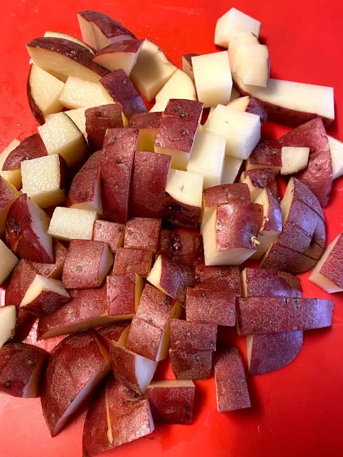 washed and cubed red potatoes on cutting board