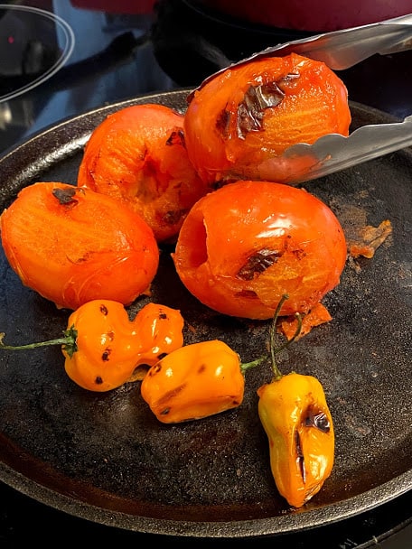 dry roasted tomatoes and habanero peppers on cast iron griddle