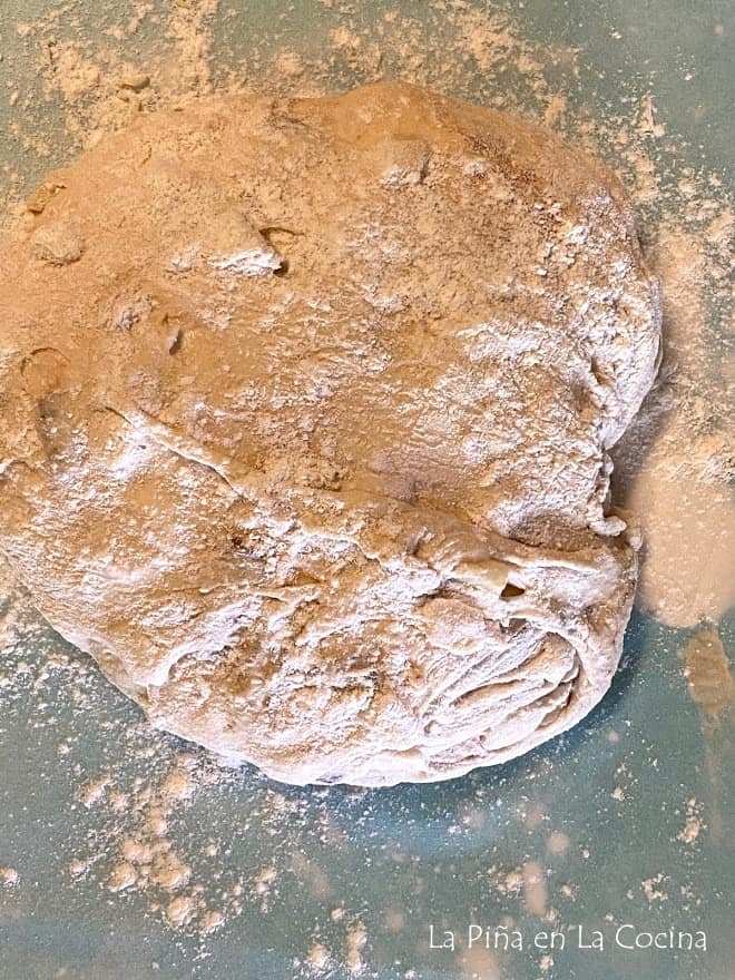 bread dough with a generous amount of flour before shaping into round loaf