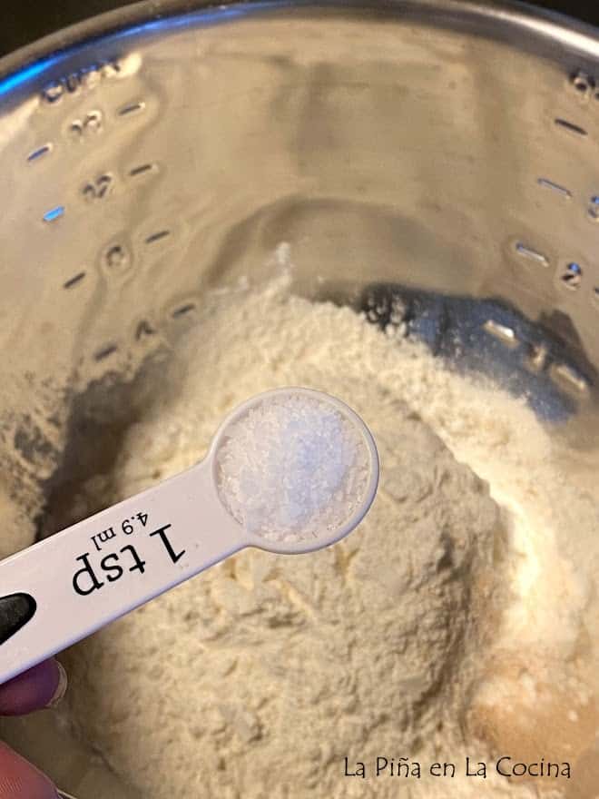 adding kosher salt to flour in bowl