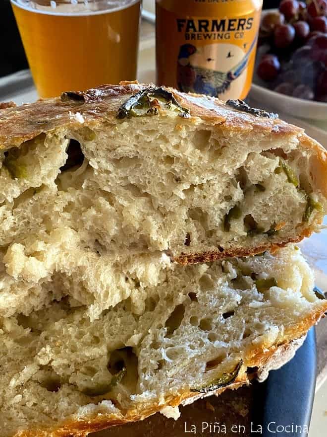 close up of sliced jalapeño loaf with glass of beer and can of beer