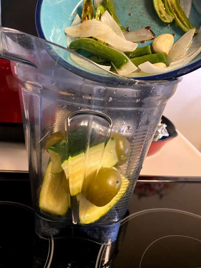 Adding all the ingredients to the blender for salsa verde