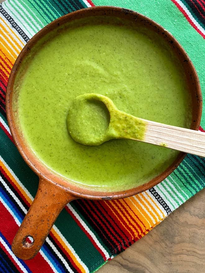 salsa verde in a bowl with wooden spoon