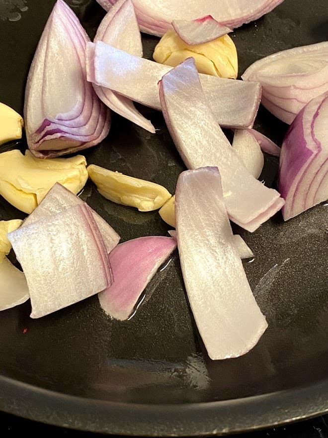 frying onions and garlic in skillet for adobo recipe