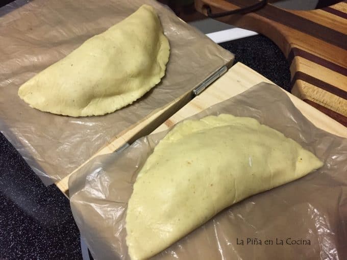 two filled uncooked quesadillas on lined tortilla press
