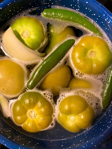 tomatillos, onion and chile serrano simmering in water