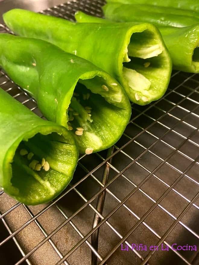 close up of green chile pods on metal rack