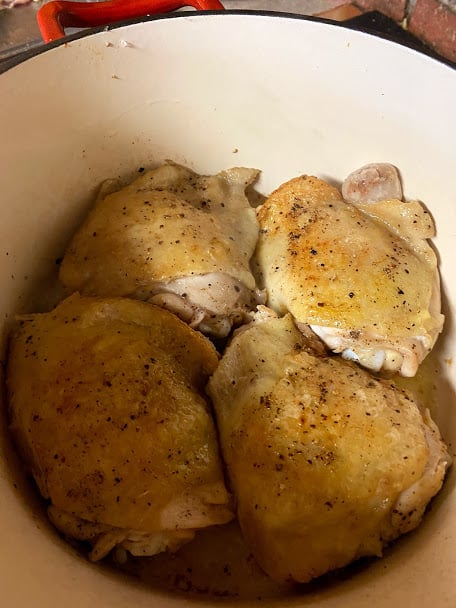 Seared chicken thighs skin side up in pot