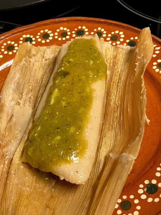 close up of chile and cheese tamal close up with salsa verede