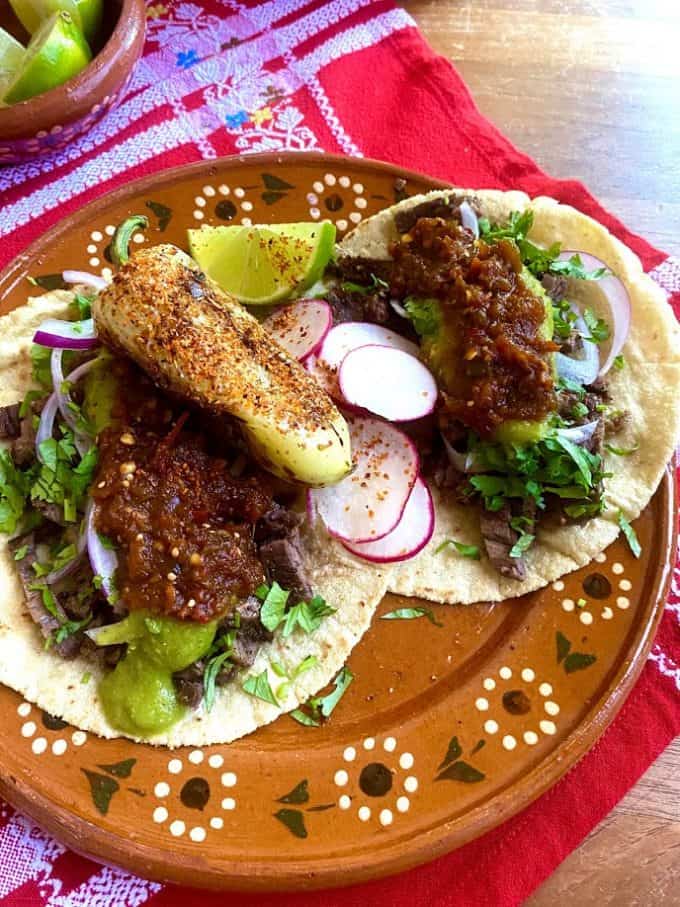 steak tacos with fresh garnishes and salsa borracha