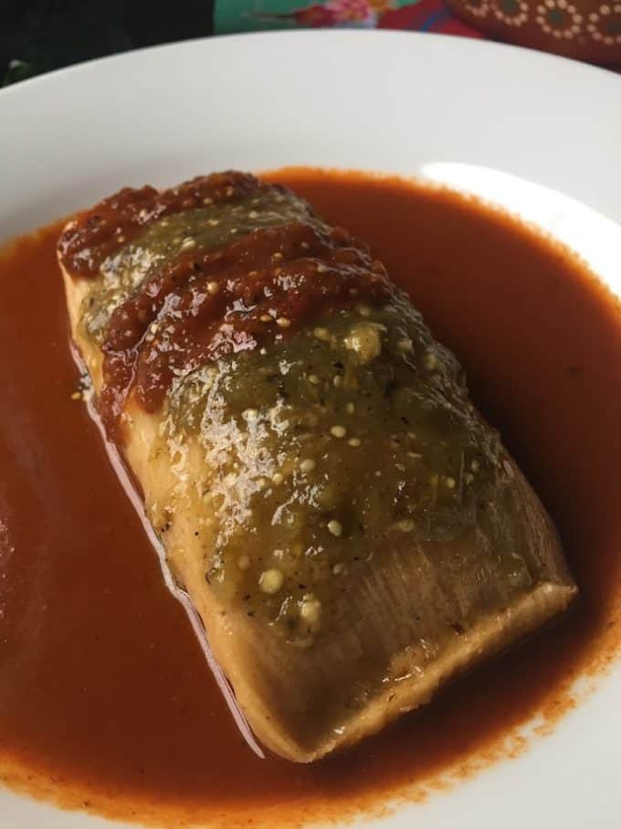 giant tamal plated with salsa garnish