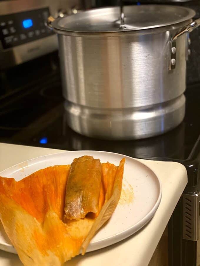 red chile pork tamal fresh out of the steamer, pot on the stove top