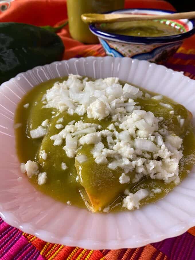 Tacos ahogados covered in warm sauce, onions and queso fresco