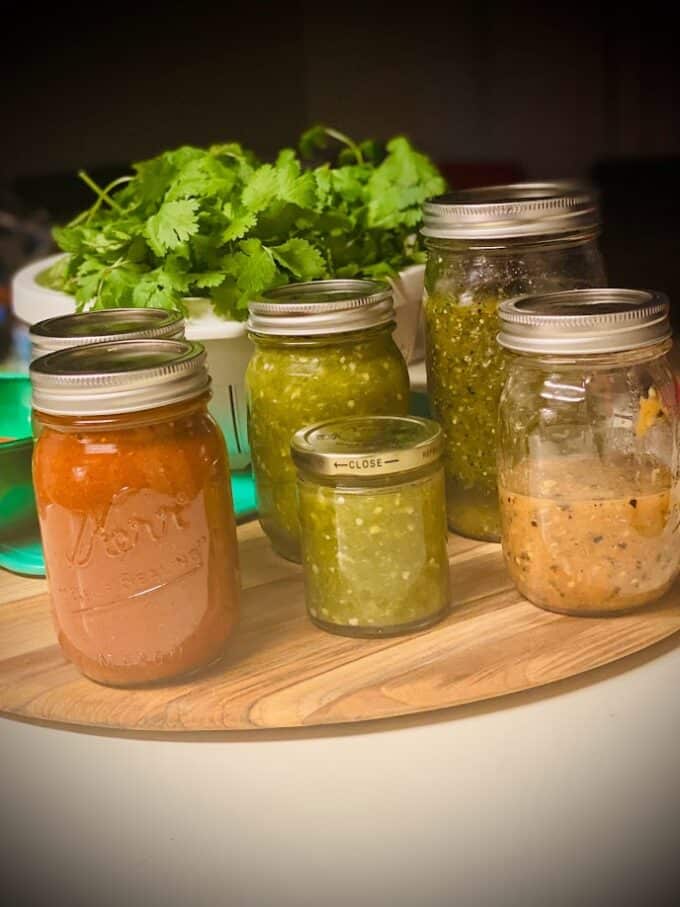 mason jars filled with different homemade salsas
