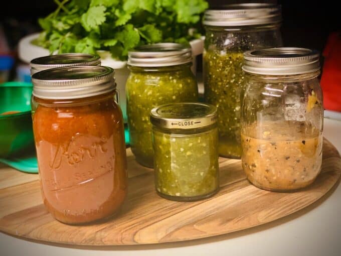 mason jars filled with different homemade salsas