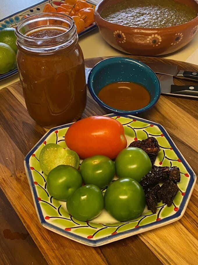 chile morita salsa in glass jar with some fresh ingredients on a plate