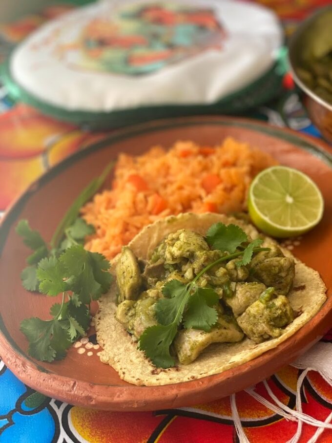 adobo verde chicken taco serve with rice, lime and cilantro garnish
