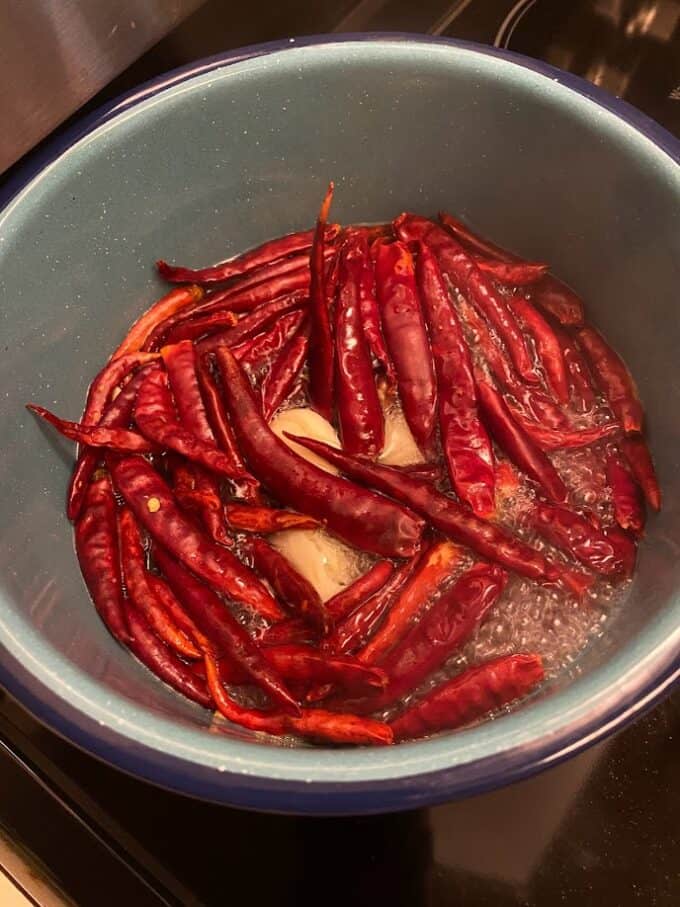 dried arbol peppers simmering in pot with ingredients