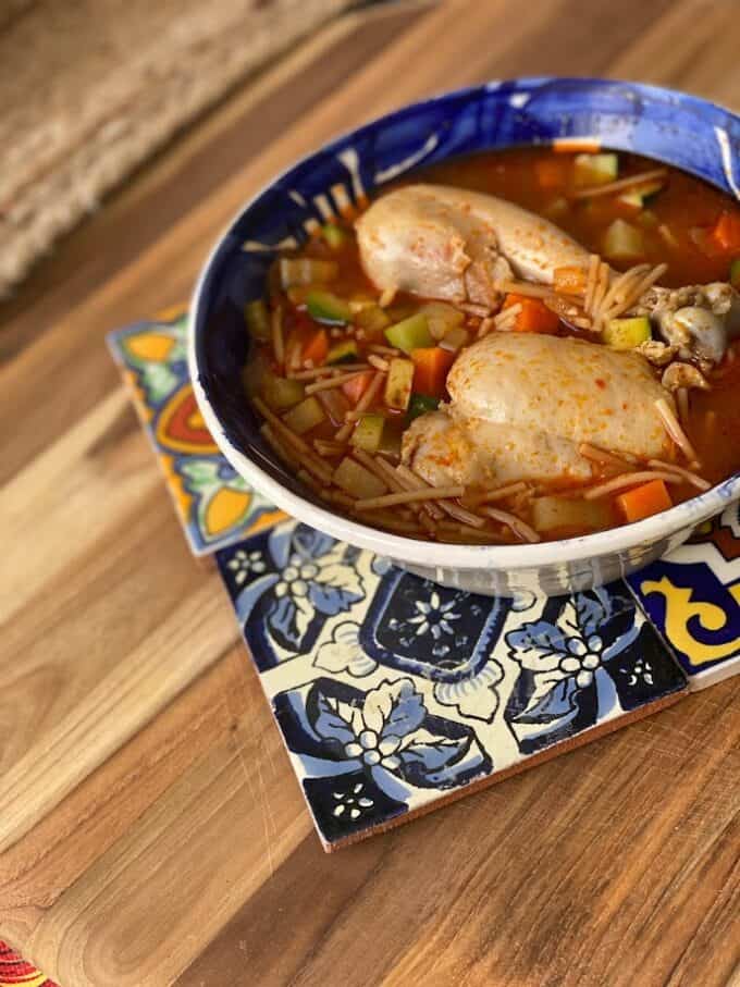 sopa in bowl with mexican tiles, wood cutting board