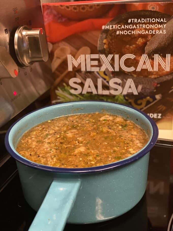 salsa in sauce pan with cookbook in the backround