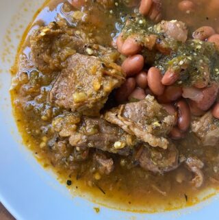 stewed beef in bowl with beans and salsa