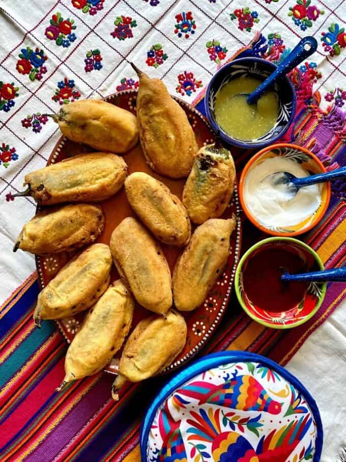 rellenos on serving platter with salsas and crema