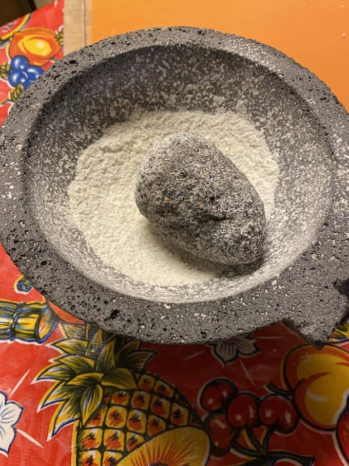 a molcajete with ground up white rice in it